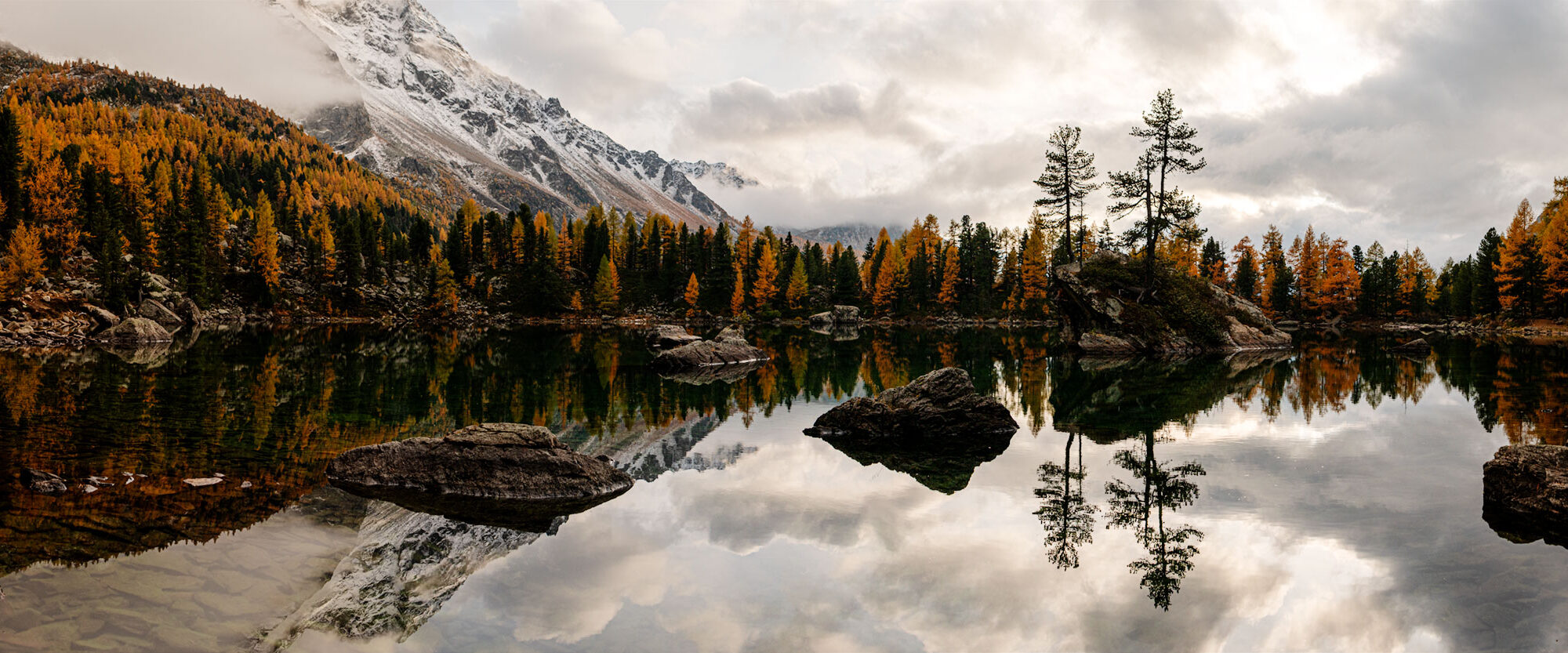 Herbstlicher Bergsee im Engadin mit goldenen Lärchen, Spiegelung und schneebedeckten Gipfeln Fotoreise Engadin goldene Lärchen