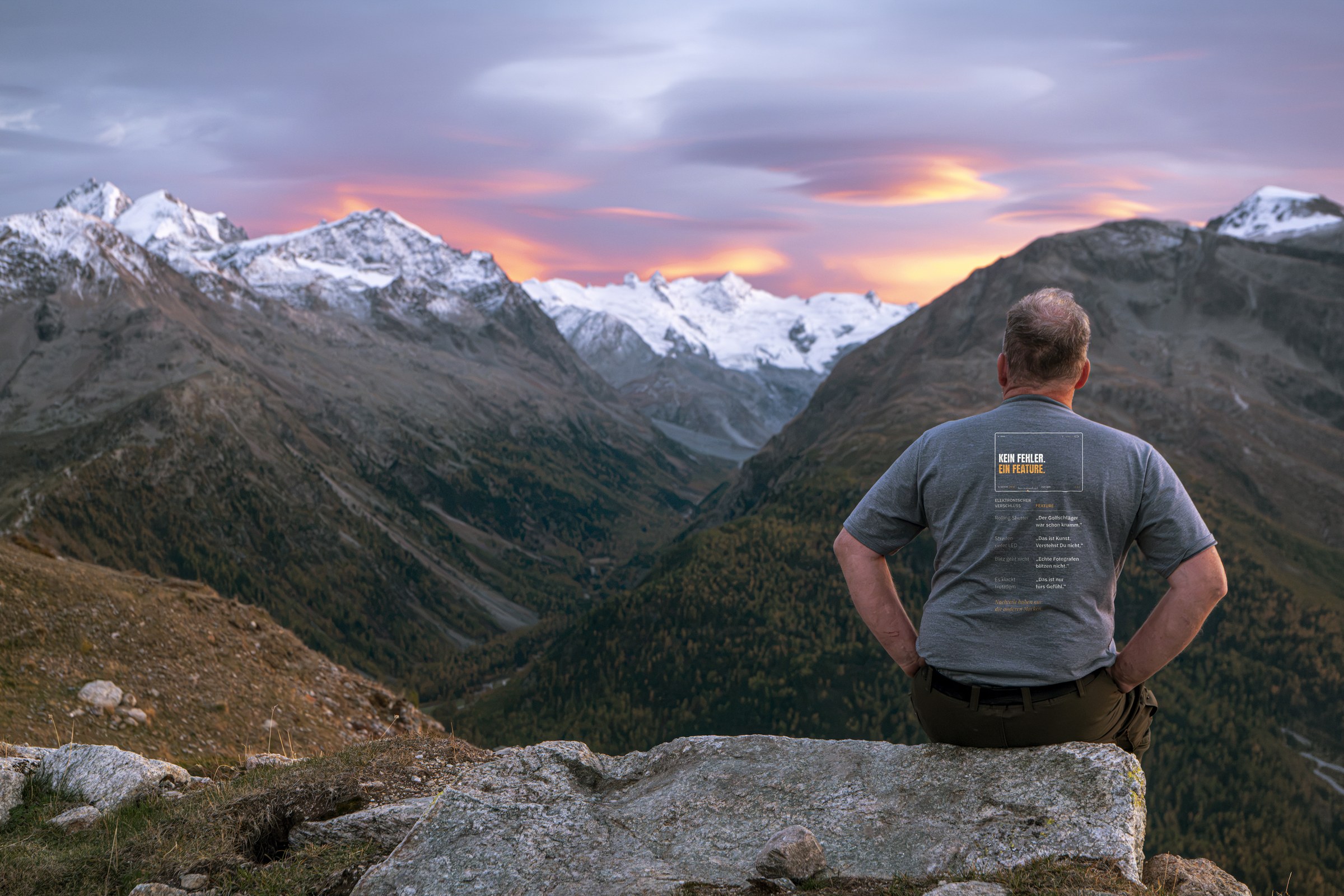 Fotografen-T-Shirt «Kein Fehler. Ein Feature.» von hemmi.photo – getragen am Berg