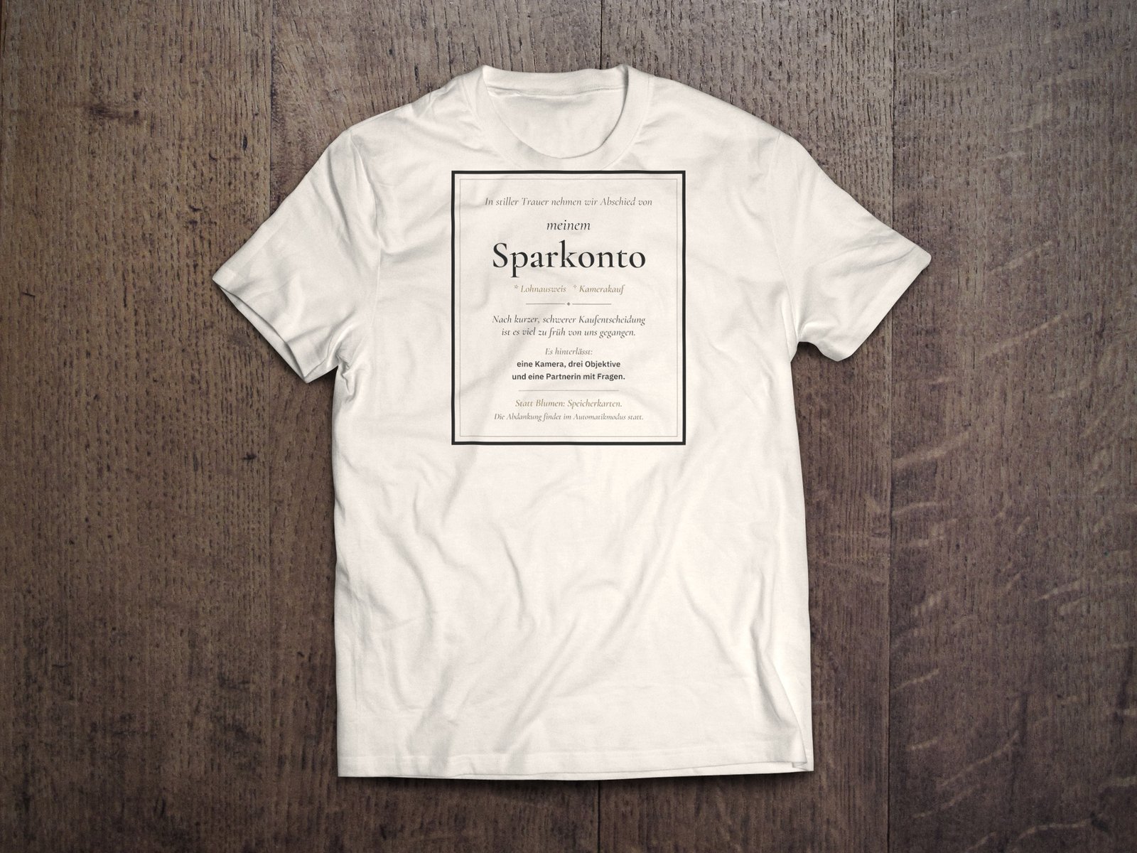 Edles Fotografen-T-Shirt «Traueranzeige Sparkonto» von hemmi.photo – Brustdruck auf Off White