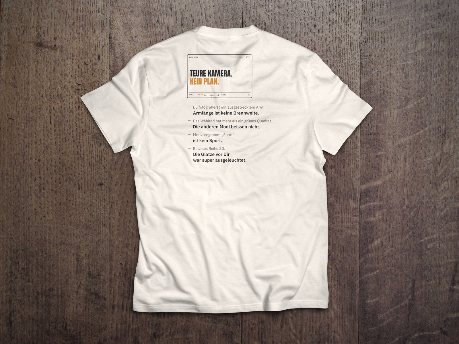 Fotografen-T-Shirt «Teure Kamera» – Orange von hemmi.photo – Rückendruck auf Off White