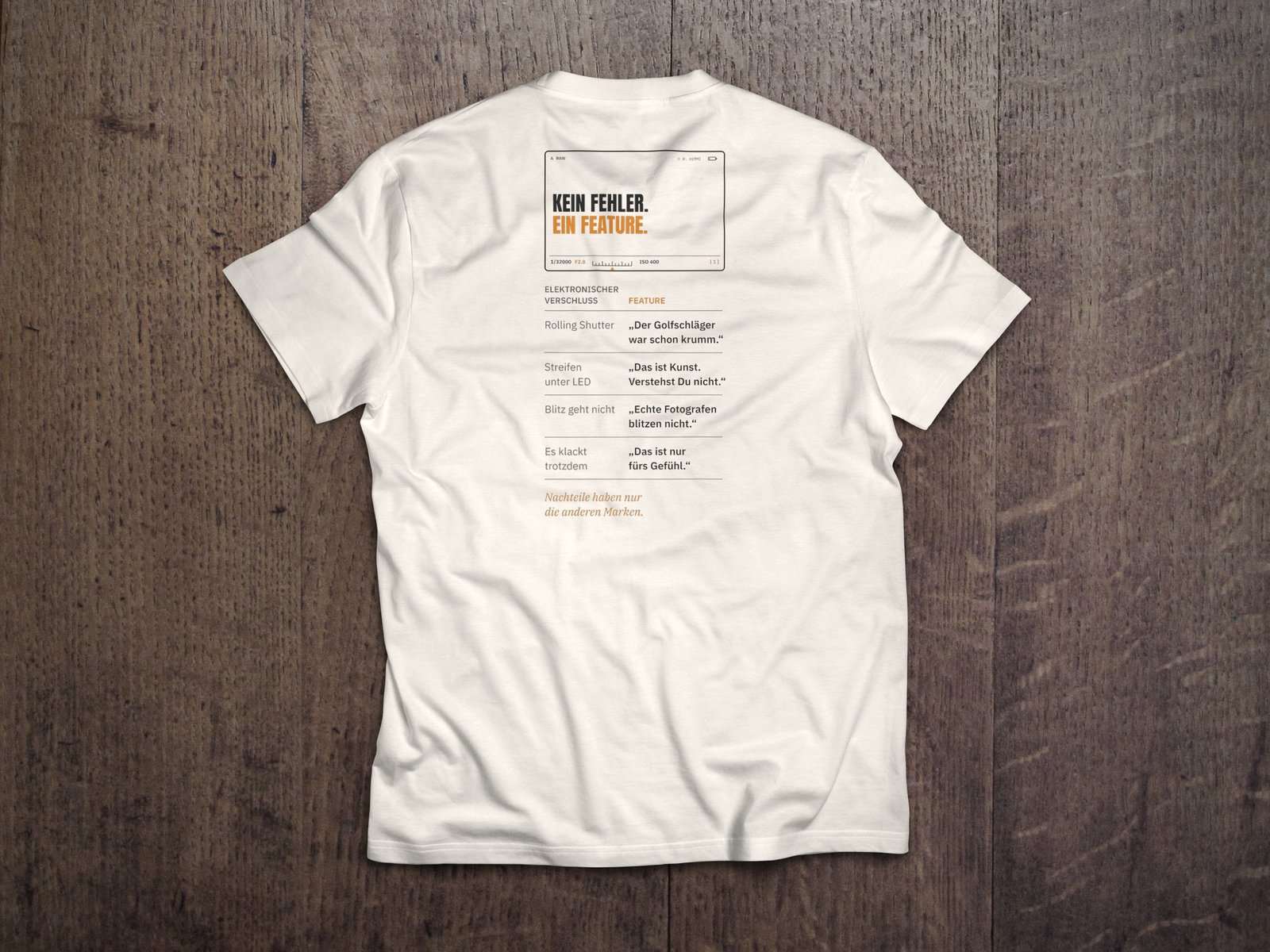 Fotografen-T-Shirt «Kein Fehler. Ein Feature.» von hemmi.photo – Rückendruck auf Off White
